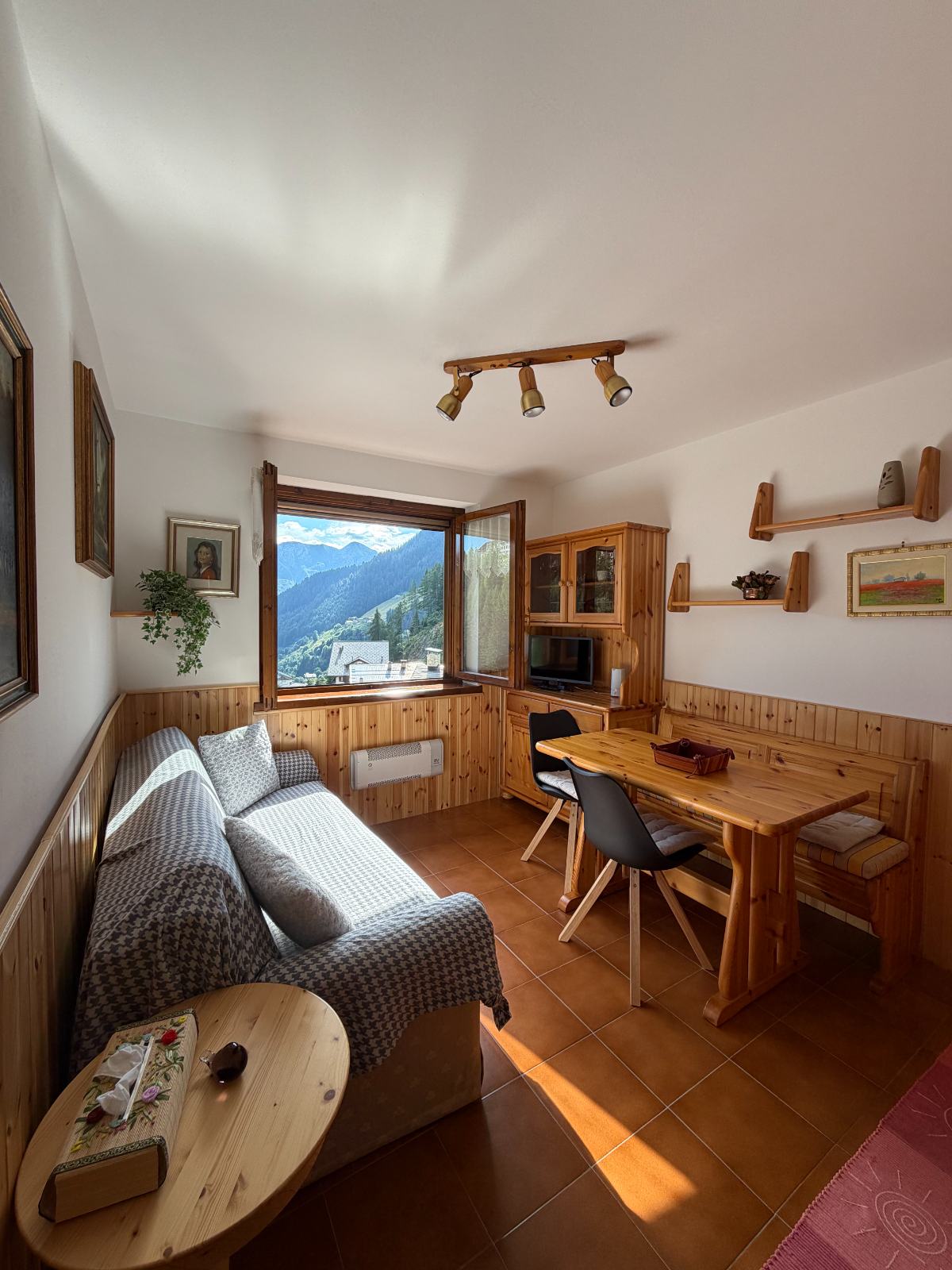 Soggiorno con divano letto, tavolo e finestra sulla valle